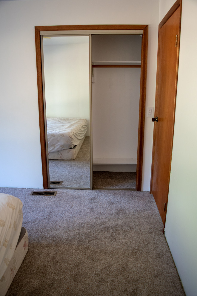 Diseño de dormitorio principal rústico de tamaño medio con paredes blancas, moqueta y suelo multicolor