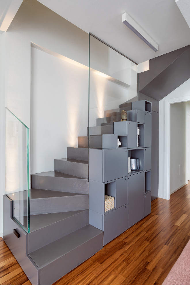 Inspiration for a mid-sized contemporary concrete l-shaped staircase in Bologna with concrete risers and glass railing.