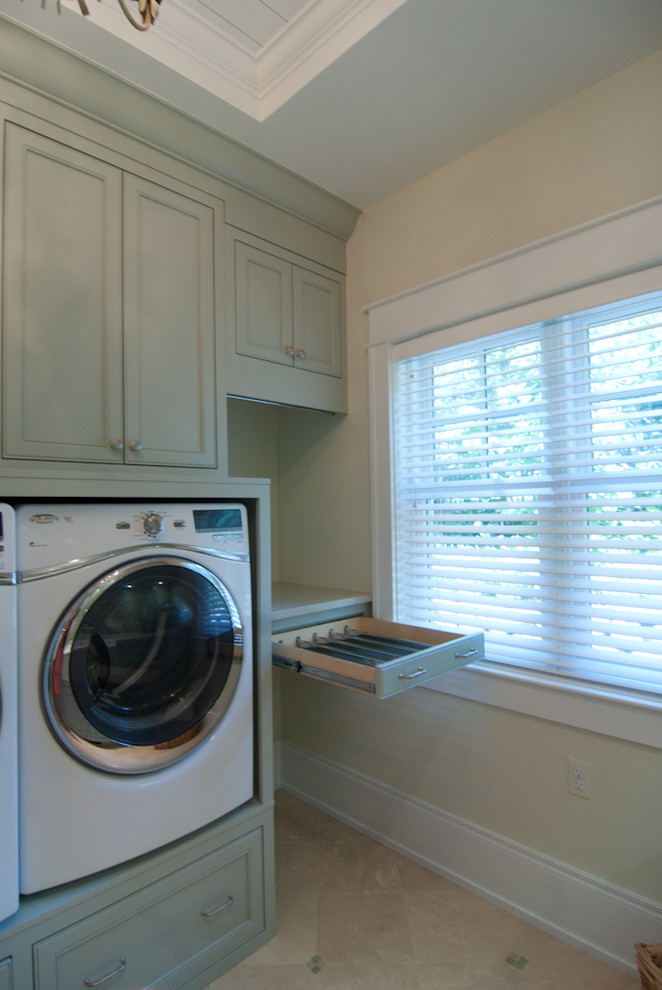 Large galley dedicated laundry room in Grand Rapids with a farmhouse sink, recessed-panel cabinets, green cabinets, quartz benchtops, blue splashback, mosaic tile splashback, yellow walls, porcelain floors, an integrated washer and dryer, beige floor, beige benchtop and timber.