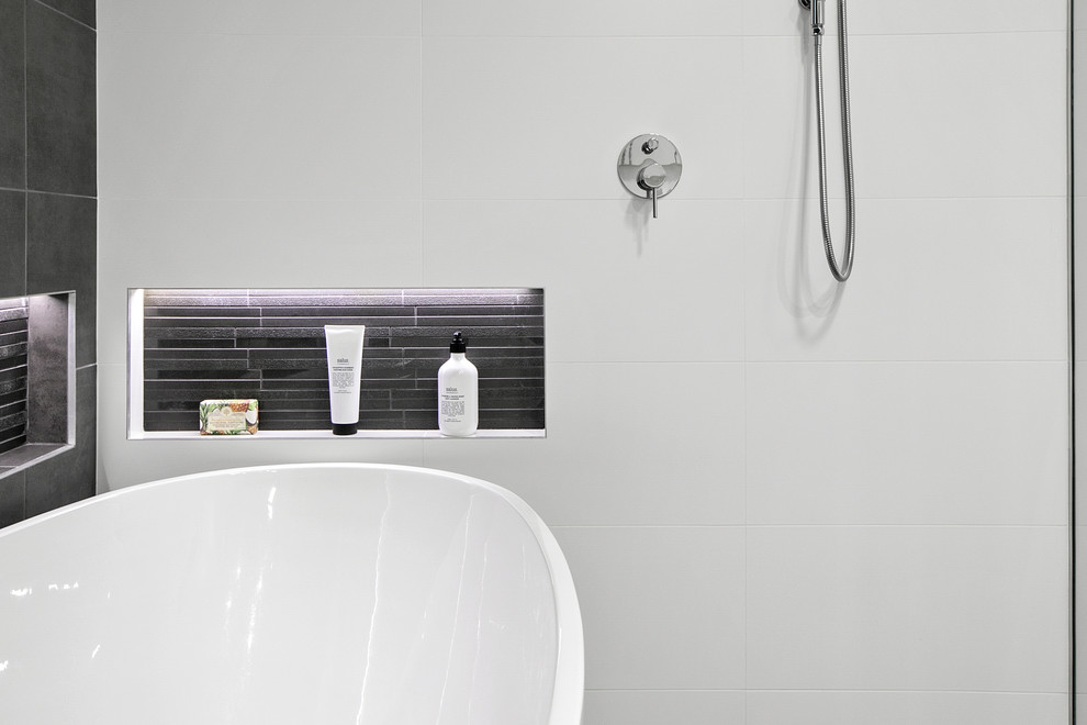 Inspiration for a mid-sized contemporary master wet room bathroom in Sydney with furniture-like cabinets, medium wood cabinets, a freestanding tub, a one-piece toilet, white tile, ceramic tile, grey walls, ceramic floors, a vessel sink, engineered quartz benchtops, grey floor, an open shower and grey benchtops.