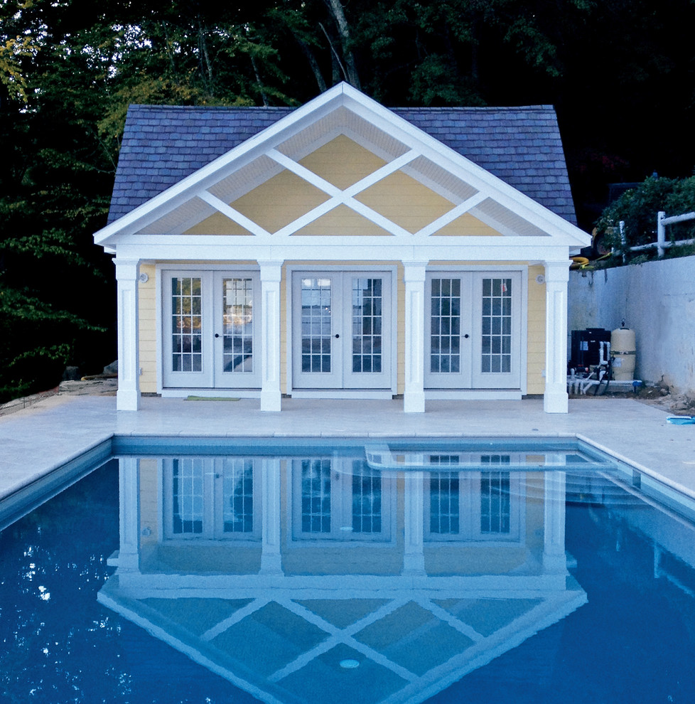 Example of a minimalist backyard stamped concrete and rectangular natural pool house design in Boston