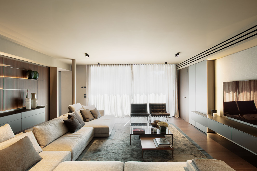 Foto di un soggiorno minimalista di medie dimensioni e chiuso con libreria, pareti beige, parquet scuro, TV a parete, pavimento marrone e tappeto