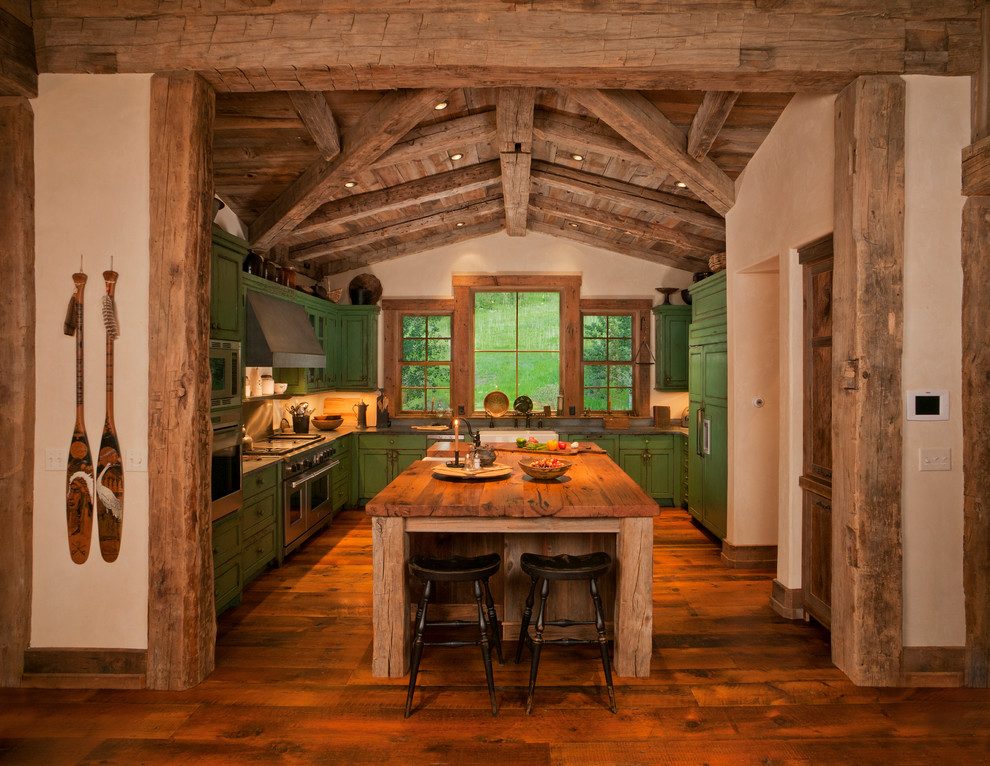 Eat-in kitchen - mid-sized rustic galley medium tone wood floor eat-in kitchen idea in Denver with a farmhouse sink, shaker cabinets, green cabinets, stainless steel appliances and an island