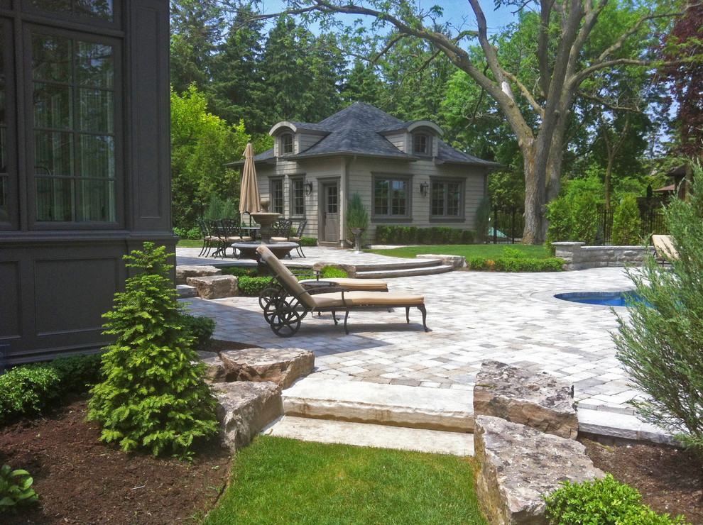 Mid-sized traditional backyard patio in Toronto with brick pavers.