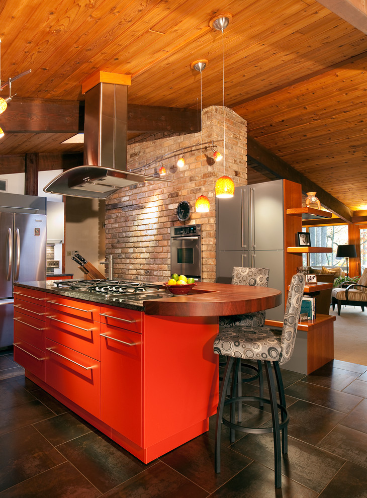 Inspiration for a mid-sized contemporary l-shaped eat-in kitchen in Raleigh with a single-bowl sink, flat-panel cabinets, red cabinets, granite benchtops, grey splashback, glass tile splashback, stainless steel appliances, porcelain floors and with island.