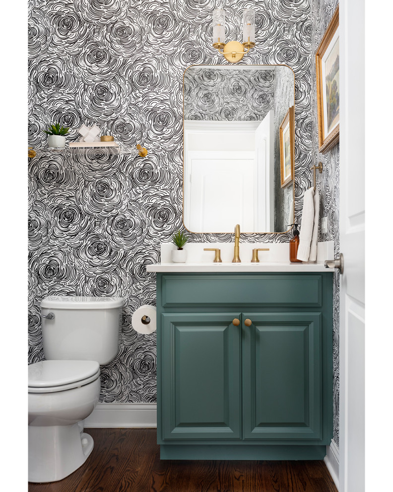 This is an example of a mid-sized transitional powder room in Chicago with multi-coloured walls, wallpaper, raised-panel cabinets, green cabinets, a two-piece toilet, an undermount sink, engineered quartz benchtops, white benchtops and a built-in vanity.