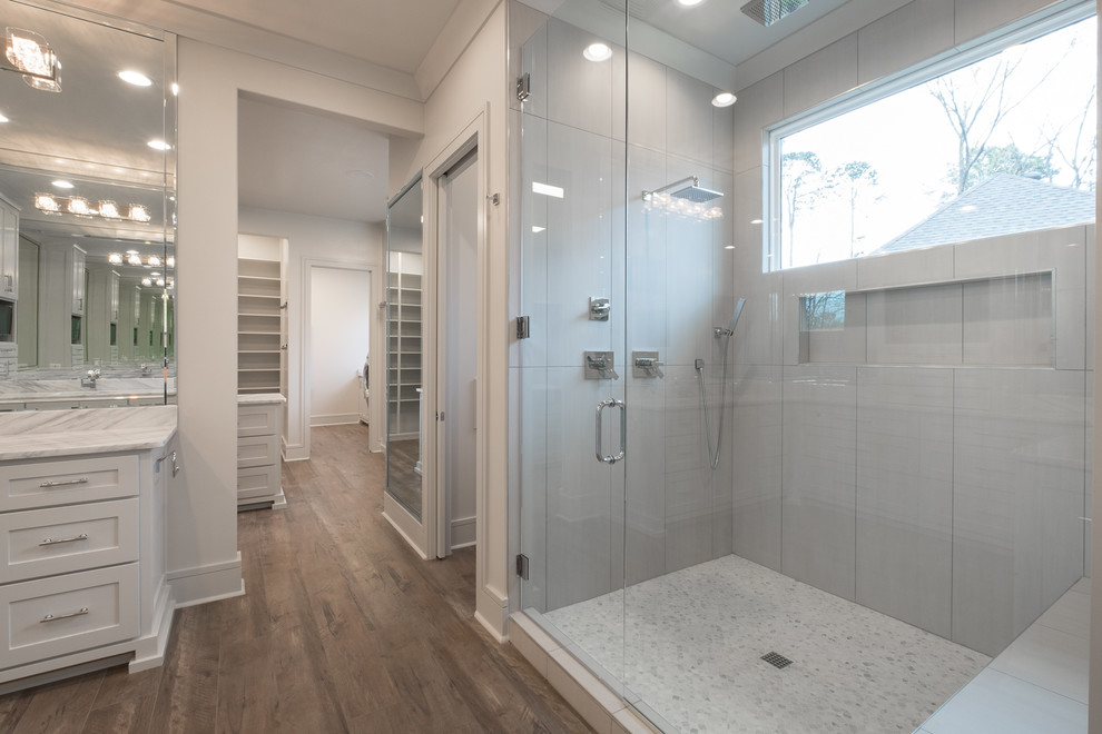 Photo of a large transitional master bathroom in Little Rock with shaker cabinets, white cabinets, an alcove shower, white walls, dark hardwood floors, an undermount sink, marble benchtops, brown floor, a hinged shower door and grey benchtops.