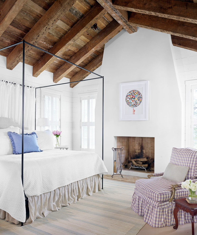 Photo of a country bedroom in Austin with white walls and a standard fireplace.