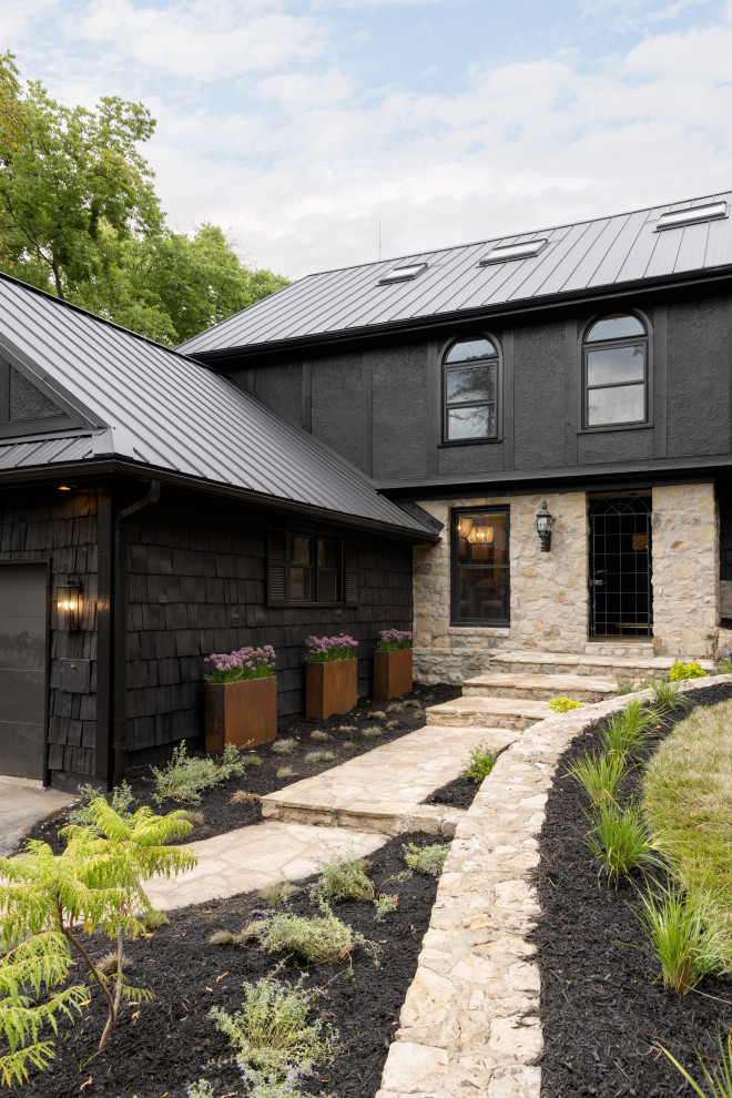Cette photo montre une façade de maison noire en bois et bardeaux à un étage avec un toit en métal et un toit noir.
