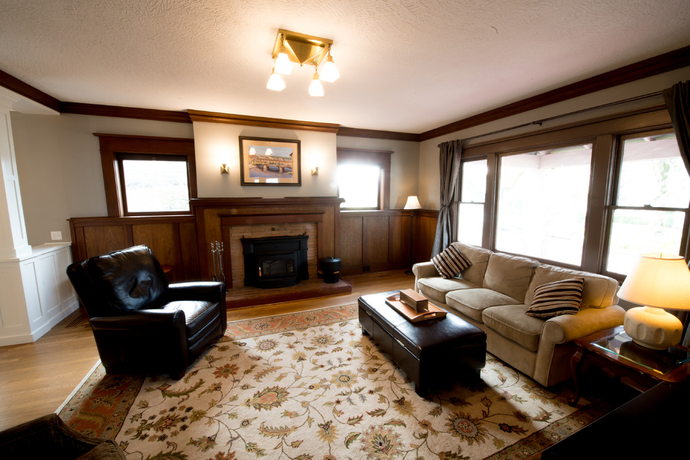 This is an example of a large arts and crafts formal enclosed living room in Portland with grey walls, a standard fireplace, brown floor, medium hardwood floors, a brick fireplace surround and no tv.