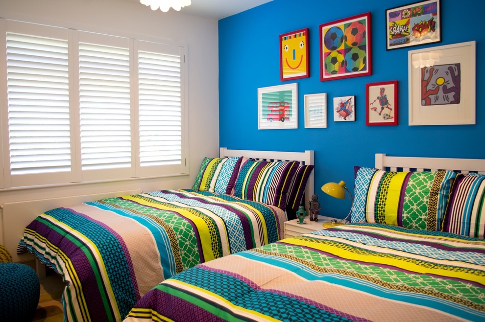 This is an example of a mid-sized contemporary kids' bedroom for boys in London with blue walls.