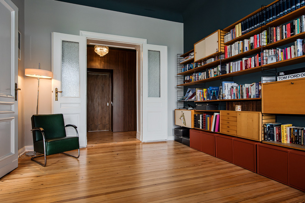 Exemple d'un grand bureau éclectique avec une bibliothèque ou un coin lecture, un mur bleu, parquet clair, un bureau indépendant et un sol marron.