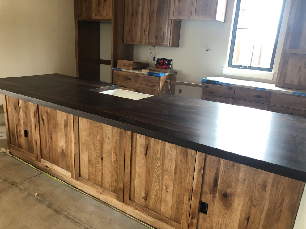 Large mountain style galley eat-in kitchen photo in Austin with a farmhouse sink, recessed-panel cabinets, light wood cabinets and an island