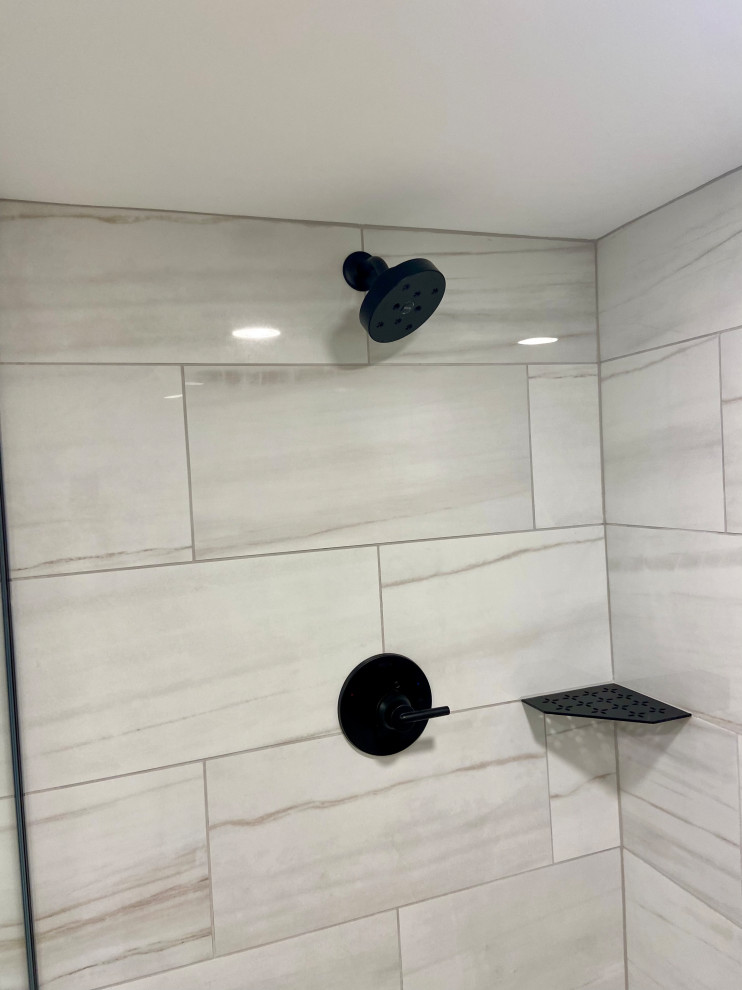 This is an example of a small modern shower room bathroom in Chicago with shaker cabinets, black cabinets, a walk-in shower, a two-piece toilet, grey tiles, ceramic tiles, beige walls, laminate floors, an integrated sink, engineered stone worktops, brown floors, an open shower, white worktops, a single sink and a built in vanity unit.