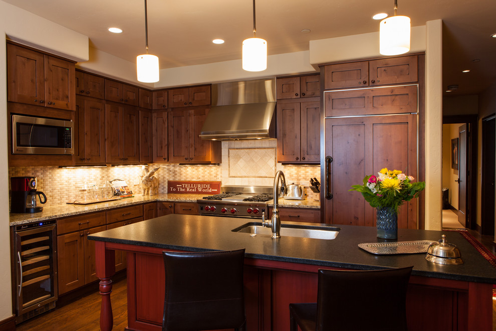 Mid-sized transitional l-shaped dark wood floor open concept kitchen photo in Denver with an undermount sink, shaker cabinets, dark wood cabinets, granite countertops, beige backsplash, mosaic tile backsplash, stainless steel appliances and an island