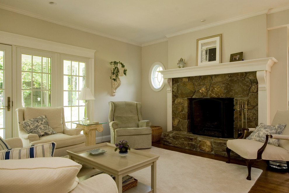 Inspiration for a mid-sized traditional formal enclosed living room in Providence with beige walls, medium hardwood floors, a standard fireplace, a stone fireplace surround and brown floor.
