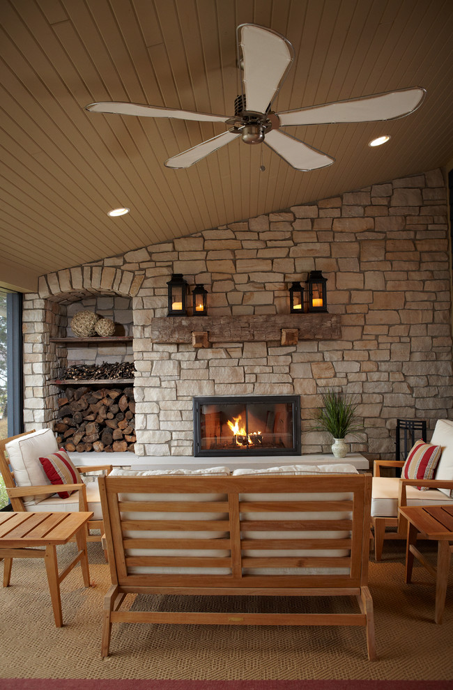 Photo of a beach style verandah in Grand Rapids with a fire feature and a roof extension.