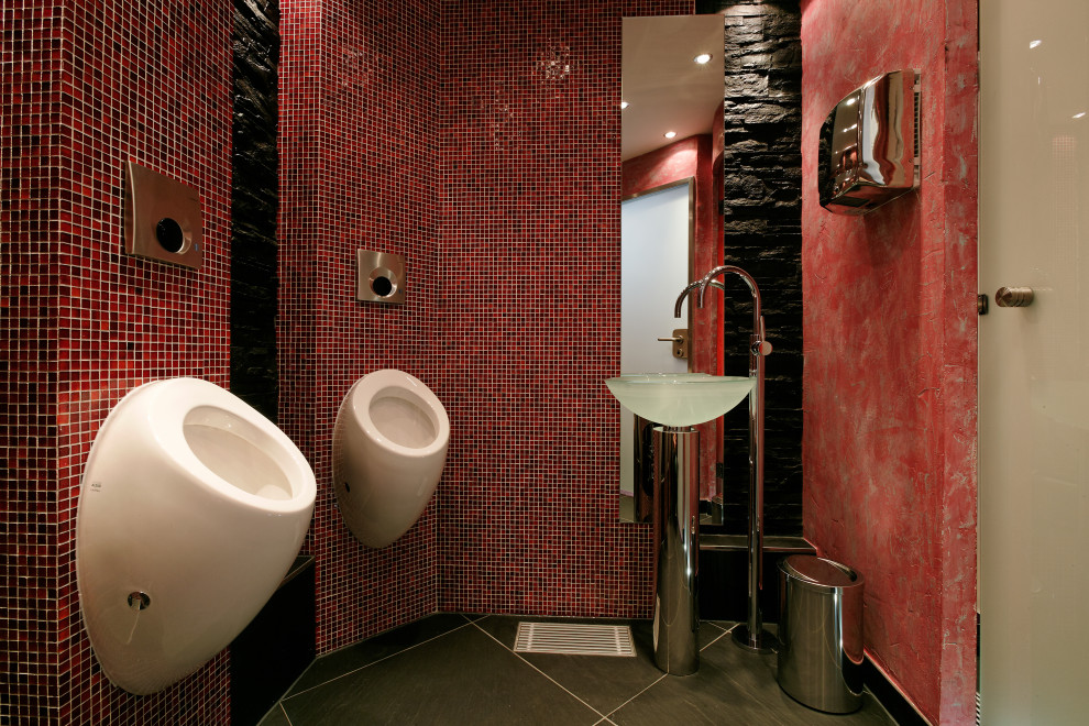 Стильный дизайн: огромный туалет: освещение в восточном стиле с инсталляцией, красной плиткой, стеклянной плиткой, черными стенами, полом из сланца, консольной раковиной, стеклянной столешницей, черным полом, напольной тумбой и многоуровневым потолком - последний тренд