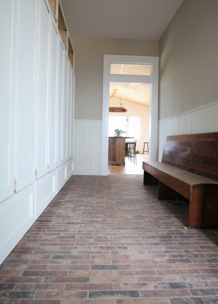 This is an example of a large farmhouse boot room in Other with porcelain flooring and multi-coloured floors.