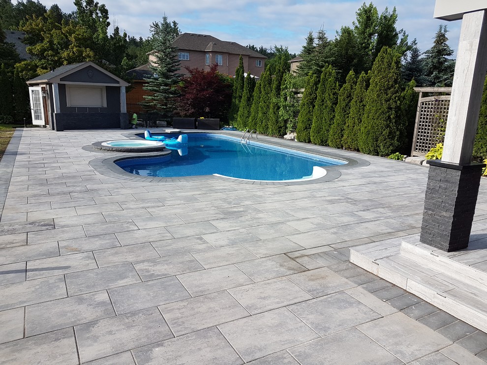 Inspiration for a large transitional backyard patio in Toronto with an outdoor kitchen, concrete pavers and a roof extension.