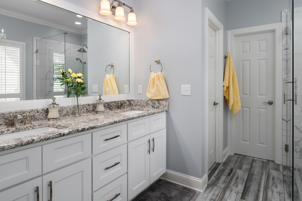Mid-sized transitional master black and white tile and porcelain tile porcelain tile and gray floor freestanding bathtub photo with shaker cabinets, white cabinets, a two-piece toilet, gray walls, an undermount sink, granite countertops, a hinged shower door and gray countertops