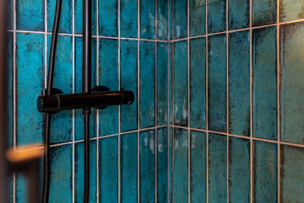 Immagine di una piccola stanza da bagno con doccia classica con doccia a filo pavimento, piastrelle blu, piastrelle in ceramica, pareti blu, lavabo da incasso, pavimento nero, doccia aperta e mobile bagno sospeso