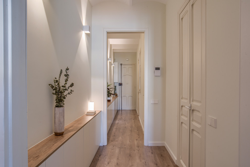 Photo of a scandinavian hallway in Barcelona with white walls, laminate floors and vaulted.