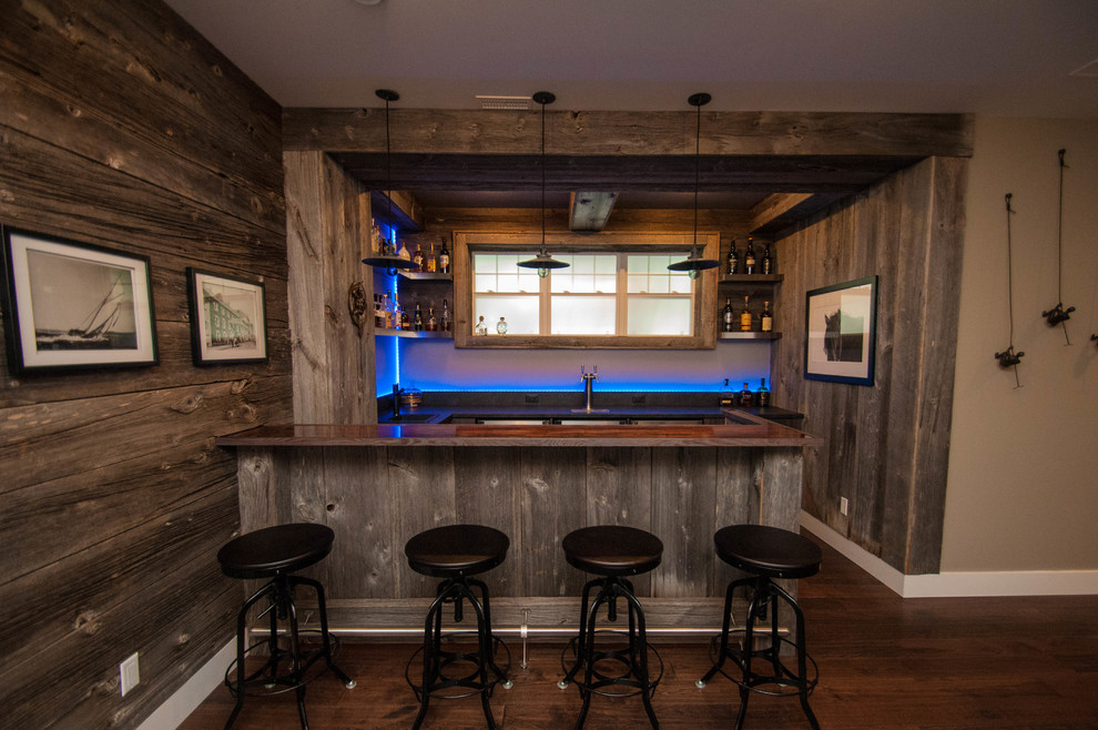 Large country u-shaped seated home bar in Other with a drop-in sink, shaker cabinets, light wood cabinets, concrete benchtops, blue splashback, glass sheet splashback, dark hardwood floors and brown floor.