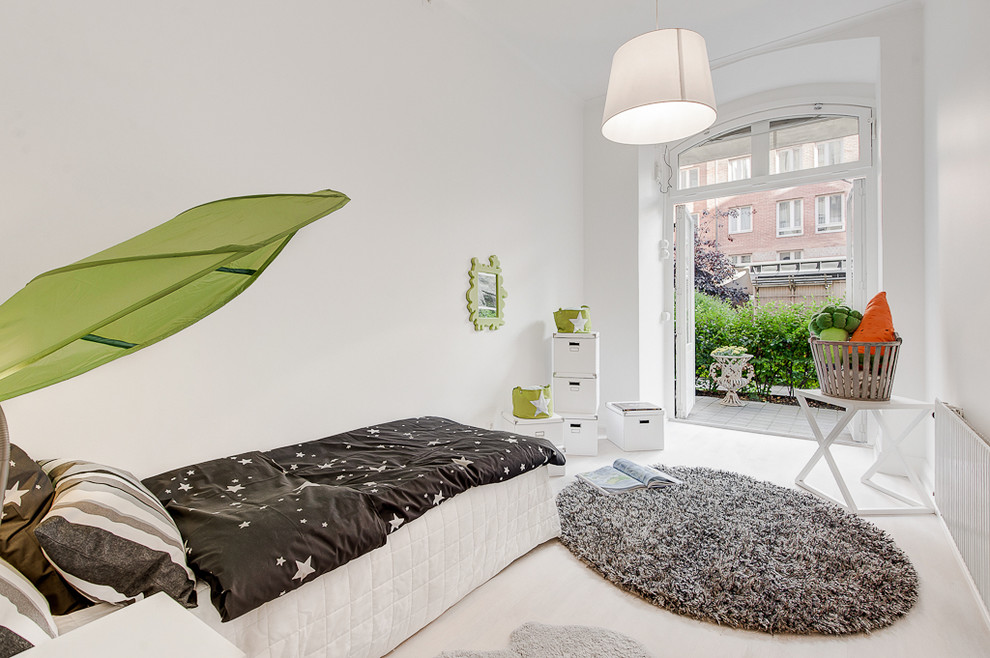 This is an example of a mid-sized scandinavian gender-neutral kids' bedroom for kids 4-10 years old in Stockholm with white walls and painted wood floors.