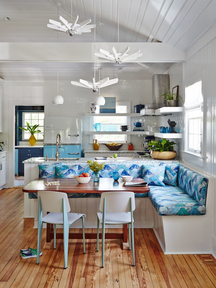 This is an example of a beach style kitchen/dining combo in Charleston with white walls and medium hardwood floors.