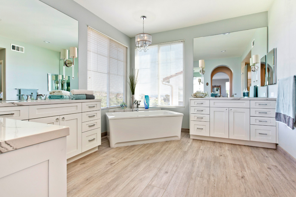 Large beach style master bathroom in Tampa with shaker cabinets, white cabinets, a freestanding tub, a corner shower, a two-piece toilet, brown tile, porcelain tile, blue walls, porcelain floors, an undermount sink and engineered quartz benchtops.