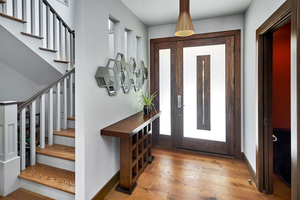Inspiration for a mid-sized contemporary foyer in San Francisco with grey walls, medium hardwood floors, a single front door and a dark wood front door.