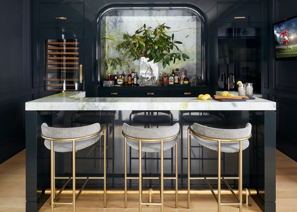 Transitional galley seated home bar in New York with beaded inset cabinets, blue cabinets, mirror splashback, medium hardwood floors, brown floor and white benchtop.