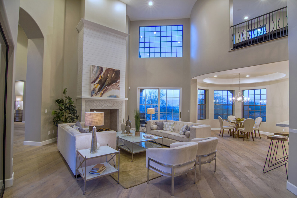This is an example of a large transitional formal open concept living room in Phoenix with brown walls, medium hardwood floors, a standard fireplace, a tile fireplace surround, no tv and brown floor.