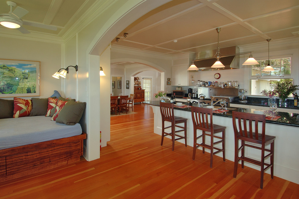 Mid-sized traditional single-wall eat-in kitchen in Hawaii with a double-bowl sink, white cabinets, stainless steel appliances, bamboo floors and with island.