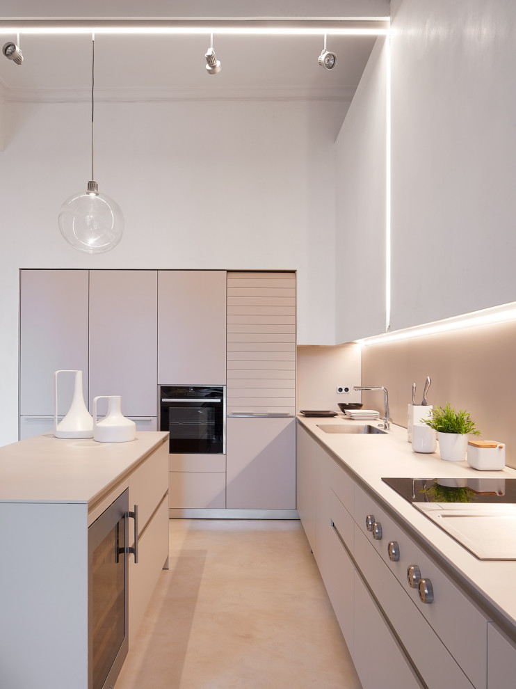 This is an example of a mid-sized contemporary single-wall eat-in kitchen in Venice with a drop-in sink, flat-panel cabinets, concrete benchtops, beige splashback, concrete floors, with island, grey floor and grey benchtop.