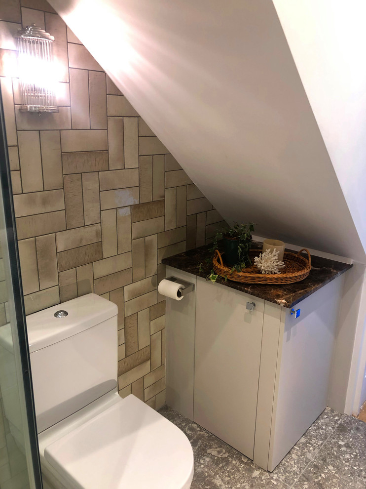 Small contemporary bathroom in London with a corner shower, a bidet, beige tile, ceramic tile, beige walls, ceramic floors, a wall-mount sink, grey floor, brown benchtops, a single vanity, a floating vanity and a hinged shower door.