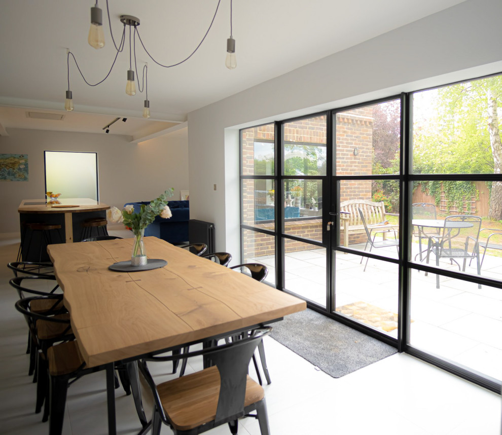 Large contemporary open plan dining room in Kent with grey walls and feature lighting.