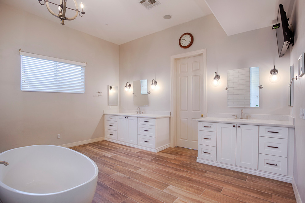 Example of a huge transitional master brown tile and porcelain tile porcelain tile freestanding bathtub design in Phoenix with shaker cabinets, white cabinets, a two-piece toilet, gray walls, an undermount sink and quartzite countertops