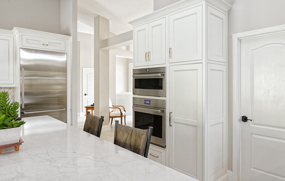 Idéer för stora vintage vitt kök, med en enkel diskho, luckor med profilerade fronter, vita skåp, bänkskiva i kvarts, vitt stänkskydd, stänkskydd i mosaik, rostfria vitvaror, klinkergolv i porslin, en köksö och vitt golv