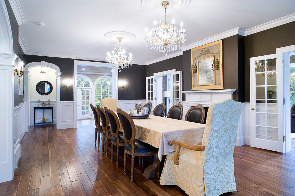 Traditional separate dining room in Other with black walls, medium hardwood floors, a standard fireplace, brown floor and decorative wall panelling.