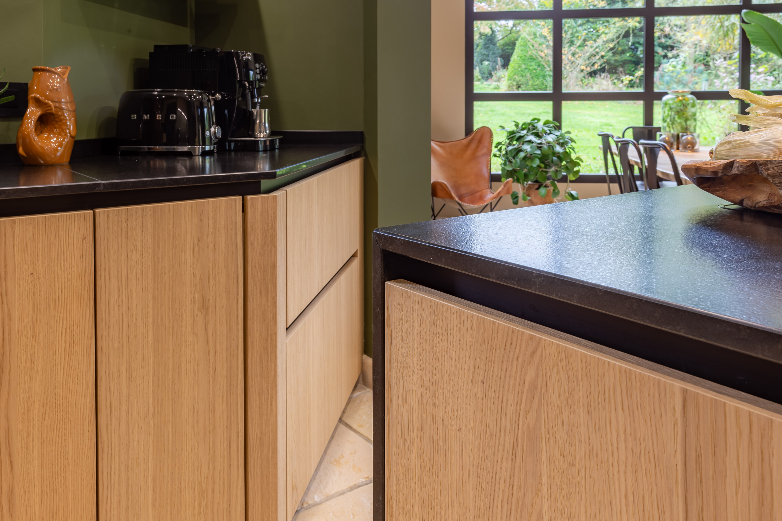 Réalisation d'une cuisine noire et bois dans un écrin végétal