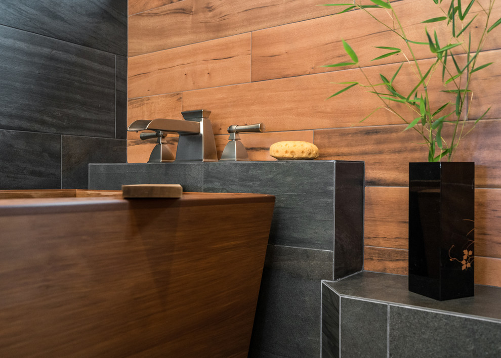 Inspiration for a transitional master bathroom in Portland with black tile, brown tile, a freestanding tub, an alcove shower, porcelain tile, beige walls, porcelain floors, beige floor and a hinged shower door.