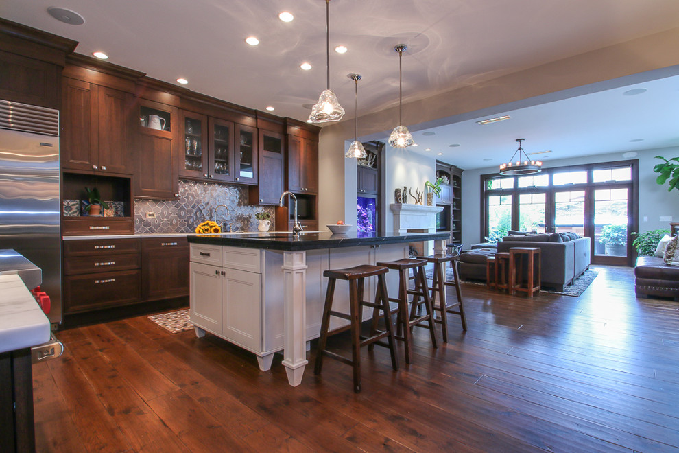 Example of a large transitional medium tone wood floor open concept kitchen design in Chicago with flat-panel cabinets, medium tone wood cabinets, marble countertops, blue backsplash, ceramic backsplash, stainless steel appliances and an island
