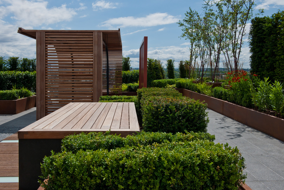 This is an example of a small contemporary rooftop deck in London with a water feature and a pergola.