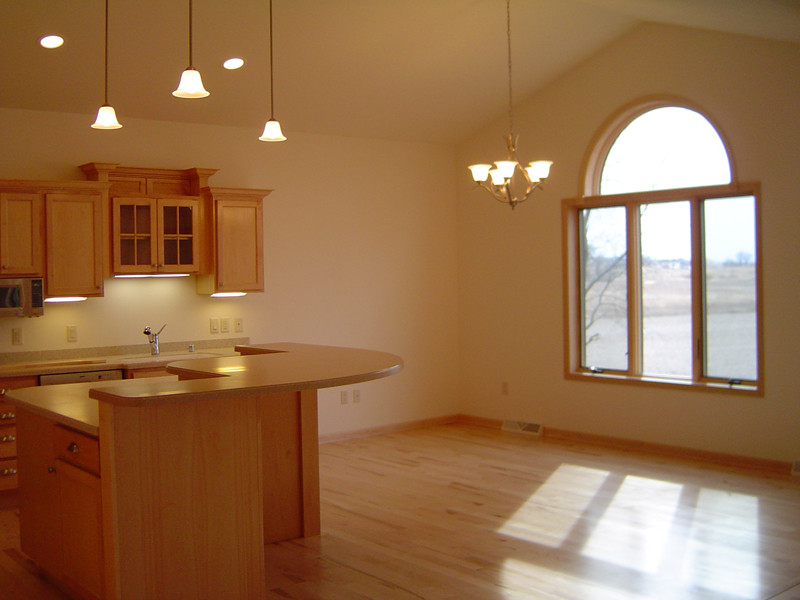 Eat-in kitchen - mid-sized transitional l-shaped light wood floor eat-in kitchen idea with a double-bowl sink, flat-panel cabinets, light wood cabinets, solid surface countertops, stainless steel appliances and an island