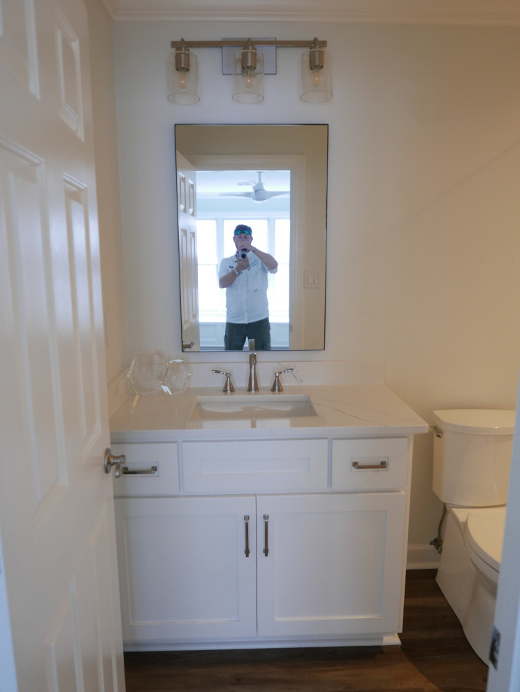 Photo of a medium sized contemporary family bathroom in Other with shaker cabinets, white cabinets, an alcove shower, a two-piece toilet, multi-coloured tiles, porcelain tiles, grey walls, vinyl flooring, a submerged sink, engineered stone worktops, brown floors, a hinged door, white worktops, a wall niche, a single sink and a built in vanity unit.