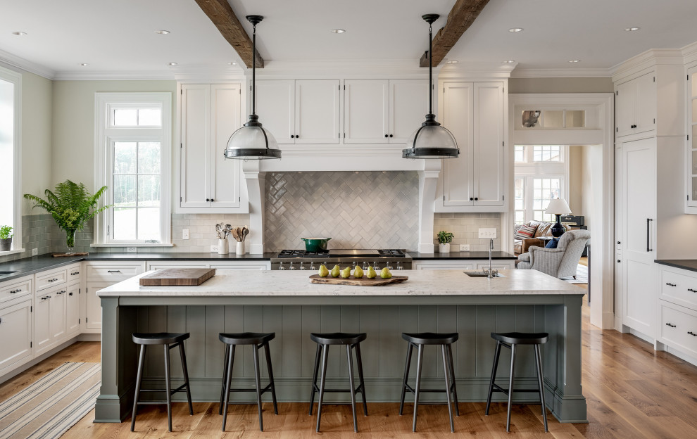 Inspiration for a large traditional l-shaped eat-in kitchen in Bridgeport with an undermount sink, flat-panel cabinets, white cabinets, granite benchtops, grey splashback, ceramic splashback, stainless steel appliances, light hardwood floors, with island, beige floor, black benchtop and exposed beam.