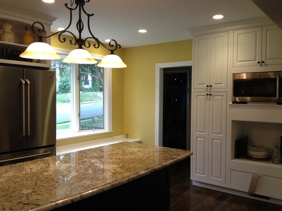 U-shaped dark wood floor enclosed kitchen photo in DC Metro with raised-panel cabinets, white cabinets, stainless steel appliances and an island