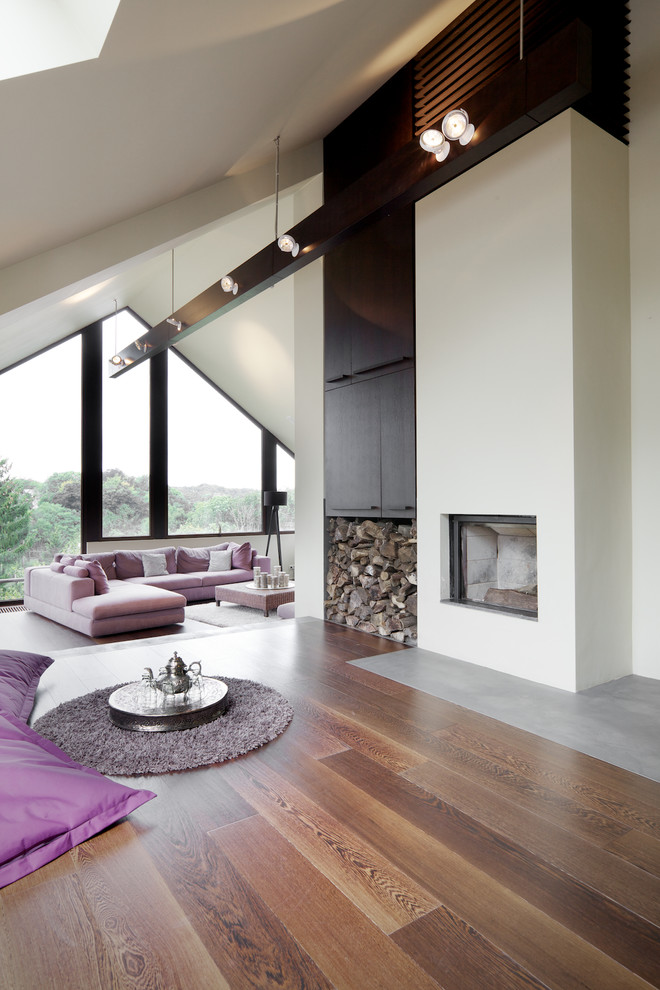 Photo of a contemporary family room in Brussels with white walls, dark hardwood floors and a standard fireplace.